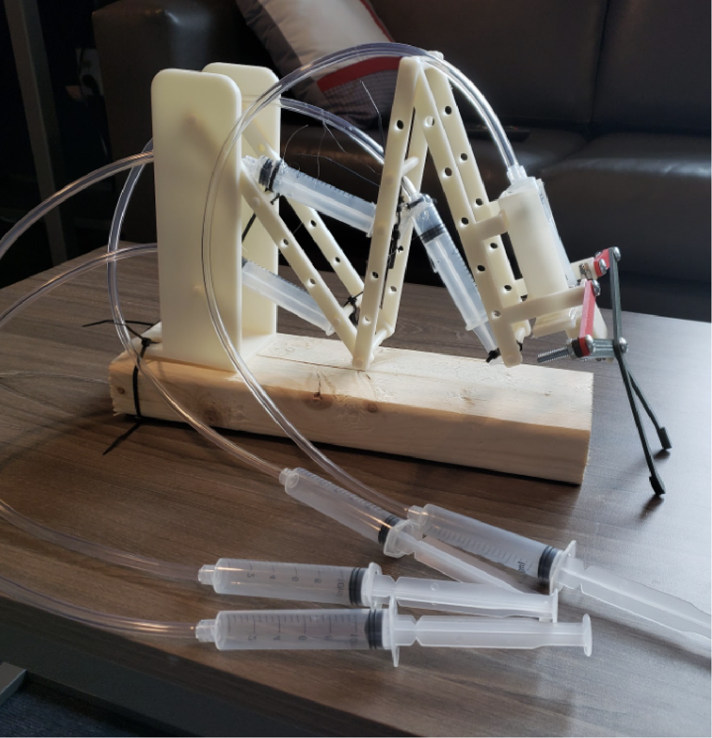 pneumatic arm prototype using syringes, tubes, connector arms, joint arms, and a robotic frame